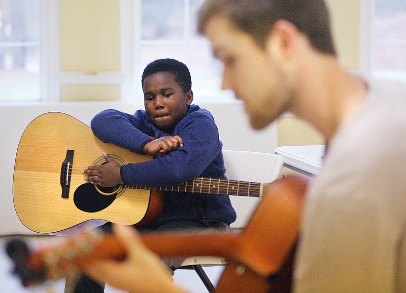 Staff file photo by Erin O. Smith / Grayson Strickland, 10, watches as Taylor Moenning, an instructor with the Songbirds Foundation, teaches chords Monday, Feb. 19, 2018 at Grace Pointe Church in Chattanooga, Tenn. The foundation gives kids guitars and lessons and will be moving its operation into the former Songbirds Guitar Museum space at the Chattanooga Choo Choo.