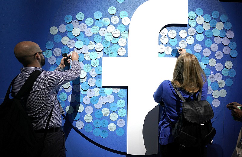 FILE - In this Tuesday, April 30, 2019 file photo, attendees stick notes on a Facebook logo at F8, the Facebook's developer conference, in San Jose, Calif. Facebook lost a legal battle Friday, May 14, 2021 with Ireland's data privacy watchdog over a European Union privacy decision that could result in the social network being forced to stop transferring data to the U.S. The Irish High Court rejected Facebook's bid to block a draft decision by the country's Data Protection Commission to inquire into, and order the suspension of, the company's data flows between the European Union and the U.S. (AP Photo/Tony Avelar, file)