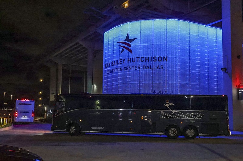 FILE - In this Wednesday, March 17, 2021, file photo, charter buses arrive at the Kay Bailey Hutchison Convention Center in Dallas, escorted by Federal Protective Service Police. (Lola Gomez/The Dallas Morning News via AP, File)



