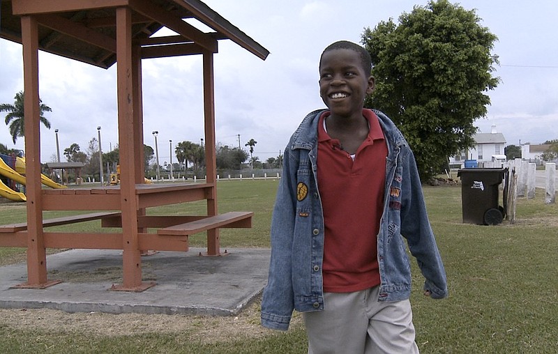 FILE - In this Jan. 13, 2009 file photo, Damon Weaver, 10, walks in a park near his home in Pahokee, Fla. Weaver, who gained national acclaim when he interviewed President Barack Obama at the White House in 2009, has died of natural causes, his family says. Weaver was 23 when he died May 1, 2021 his sister, Candace Hardy, told the Palm Beach Post. (AP Photo/ Lynne Sladky, File )


