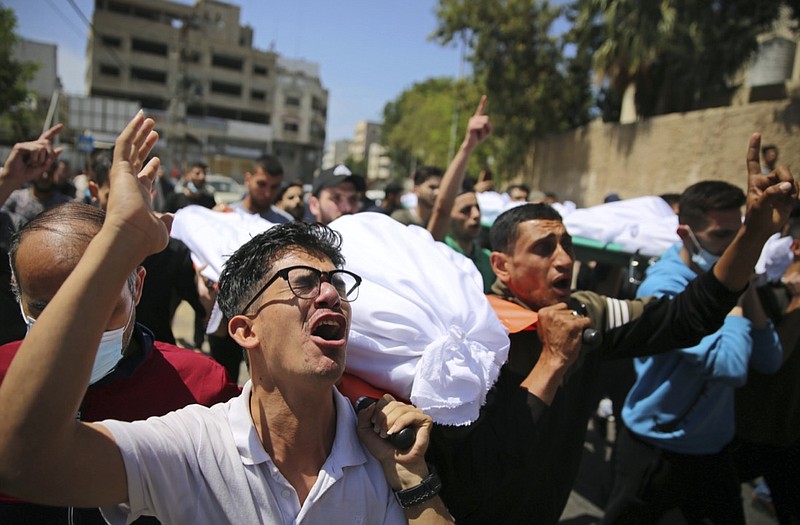 Mourners carry the the bodies of Palestinians who were killed in overnight Israeli airstrikes that hit their homes, during their funeral in Gaza City, Sunday, May 16, 2021. (AP Photo/Abdel Kareem Hana)

