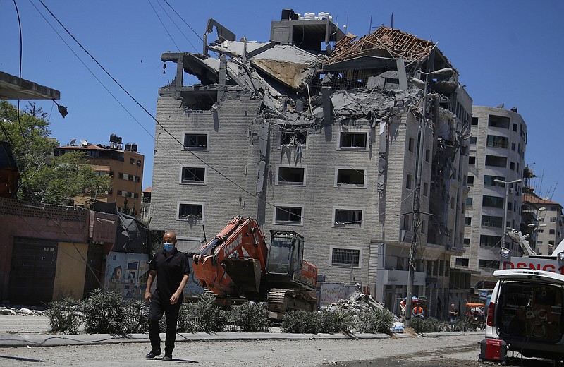 Photo by Hatem Moussa of The Associated Press / A Palestinian walks by a building hit by an Israeli airstrike in Gaza City on Tuesday, May 18, 2021. Since the fighting began last week, the Israeli military has launched hundreds of airstrikes it says are targeting Hamas' militant infrastructure, while Palestinian militants have fired thousands of rockets into Israel.