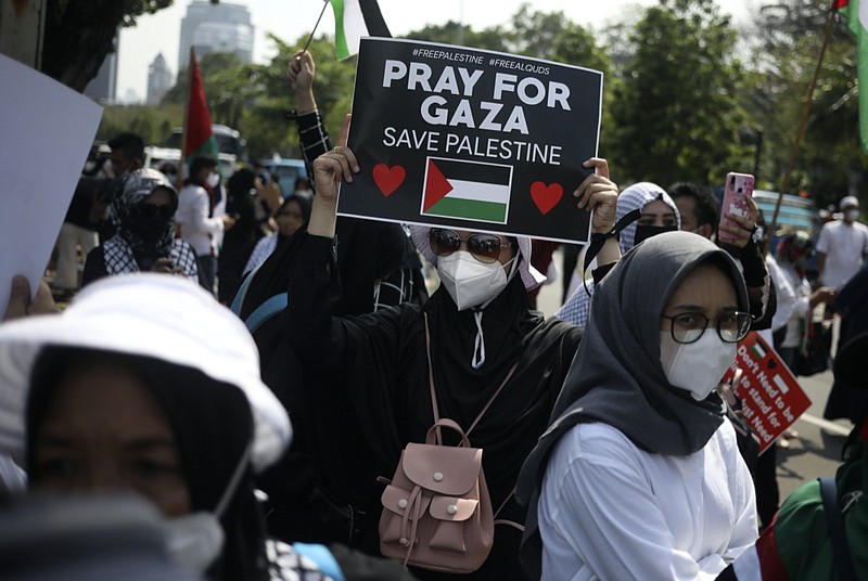 A Muslim woman holds up a poster during an anti-Israel rally outside the U.S. Embassy in Jakarta, Indonesia, Tuesday, May 18, 2021. Pro-Palestinian protesters marched to the heavily guarded U.S. Embassy in Indonesia's capital on Tuesday to demand an end to Israeli airstrikes in the Gaza Strip. (AP Photo/Dita Alangkara)