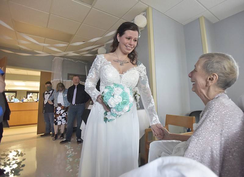 Lisa Dougherty, left, holds her mom, Debora Webb's, hand before her wedding ceremony in the Neuro-ICU at Erlanger Hospital on Wednesday evening. Webb has terminal cancer and Lisa decided to get married in the hospital so her mom could be there with her and see her wedding. Photo by Kathleen Greeson