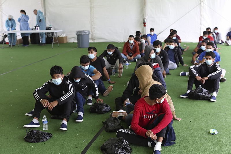 AP file photo / In this March 30, 2021, file photo, young migrants wait to be tested for COVID-19 at the Donna Department of Homeland Security holding facility, the main detention center for unaccompanied children in the Rio Grande Valley, in Donna, Texas.