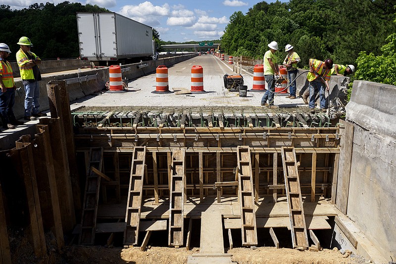 Staff photo by C.B. Schmelter / Tennessee Department of Transportation workers settle poured concrete for a back wall for the U.S. Highway 27 bridge over Big Soddy Creek on Thursday, May 20, 2021 in Soddy-Daisy, Tenn.