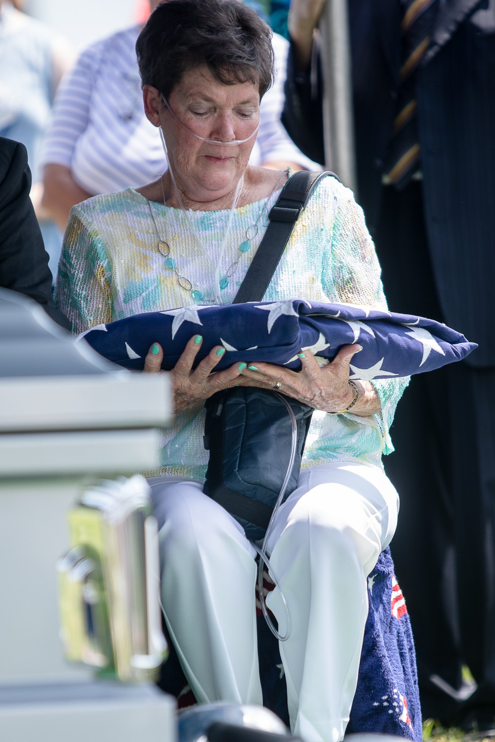 Staff photo by Troy Stolt / Evelyn Snyder, sister of the late Army Cpl. Henry L. Helms, holds her brother's flag during a funeral in his honor at Anderson Memorial Gardens on Saturday, May 22, 2021 in Ringgold, Georgia. Helms, who was ruled missing in action for seven decades, was identified by his family and given full honors with funeral rites after a 2018 meeting between North Korean Chairman Kim Jong Un and former President Donald Trump, in which an agreement was struck to repatriate remains of Americans collected from the Korean War.