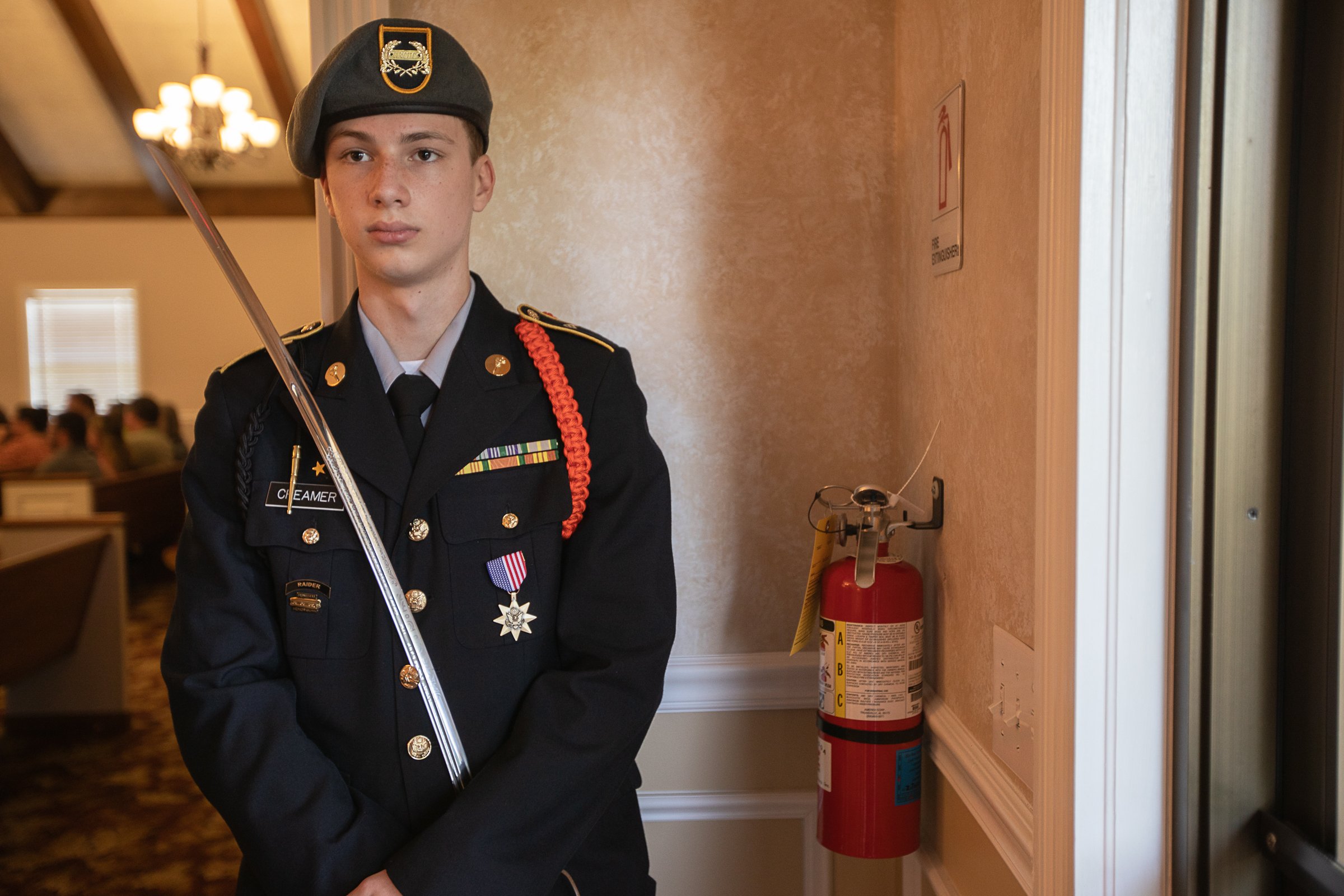 Staff photo by Troy Stolt / Ringgold high school JROTC member Nate Creamer stands at the entrance of a memorial service for Army Cpl. Henry L. Helms, who was killed in action during The Battle of Chosin Reservoir, during the Korean War on Saturday, May 22, 2021 in Ringgold, Georgia. Helms, who was ruled missing in action for seven decades, was identified by his family and given full honors with funeral rites after a 2018 meeting between North Korean Chairman Kim Jong Un and former President Donald Trump, in which an agreement was struck to repatriate remains of Americans collected from the Korean War.