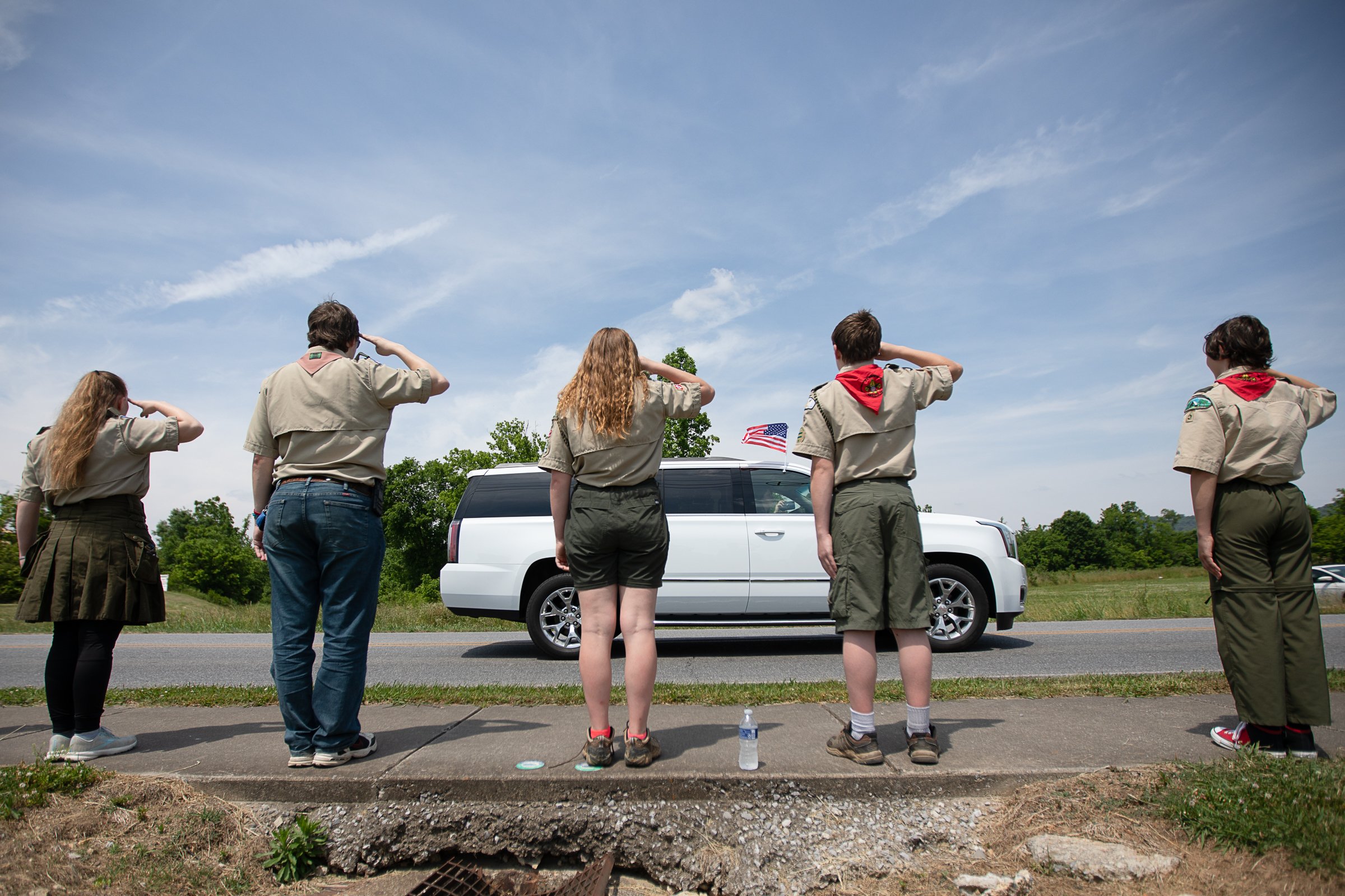Staff photo by Troy Stolt / Members of the Tennessee Boy Scout Troop 5 salute a funeral procession for Army Cpl. Henry L. Helms, who was killed in action at The Battle of Chosin Reservoir, during the Korean War on Saturday, May 22, 2021 in Ringgold, Georgia. Helms, who was ruled missing in action for seven decades, was identified by his family and given full honors with funeral rites after a 2018 meeting between North Korean Chairman Kim Jong Un and former President Donald Trump, in which an agreement was struck to repatriate remains of Americans collected from the Korean War.