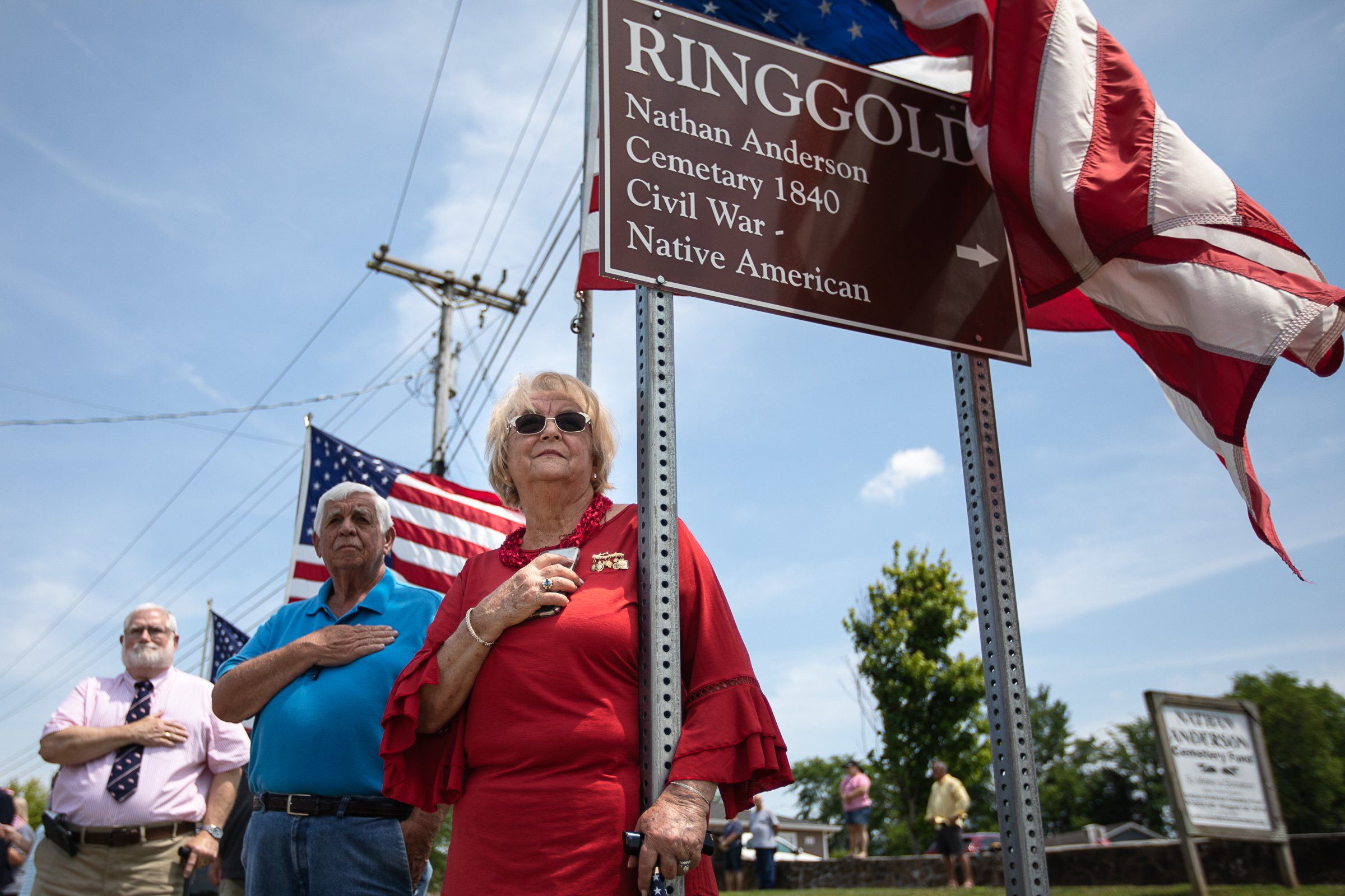 Staff photo by Troy Stolt / Yvonne Morgan, right, her husband Dewayne, center, and Bruce Phillips, left hold their hands across their heart as they watch a funeral procession for Army Cpl. Henry L. Helms, who was killed in action at The Battle of Chosin Reservoir during the Korean War drive into Anderson Memorial Gardens on Saturday, May 22, 2021 in Ringgold, Georgia. Helms, who was ruled missing in action for seven decades, was identified by his family and given full honors with funeral rites after a 2018 meeting between North Korean Chairman Kim Jong Un and former President Donald Trump, in which an agreement was struck to repatriate remains of Americans collected from the Korean War.