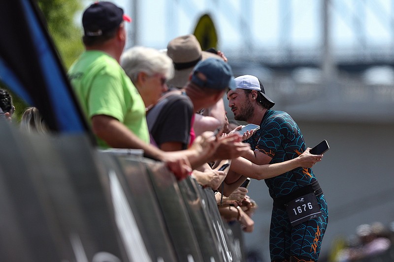 Staff photo by Troy Stolt / A triathlete hugs a loved one at the finish line of the Sunbelt Bakery Ironman 70.3 on Sunday in Chattanooga.