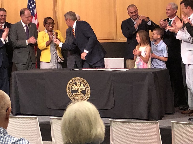Gov. Bill Lee hands Chattanooga City Councilwoman Demetrus Coonrod the pen he used to sign two of his criminal justice bills into law at the Tennessee State Museum in Nashville on Monday May 24, 2021. (Photo by Andy Sher/Chattanooga Times Free Press).