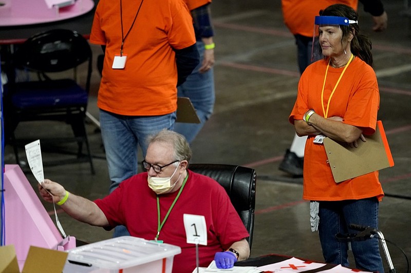 FILE - In this May 6, 2021 file photo, Maricopa County ballots cast in the 2020 general election are examined and recounted by contractors working for Florida-based company, Cyber Ninjas at Veterans Memorial Coliseum in Phoenix. (AP Photo/Matt York, Pool)


