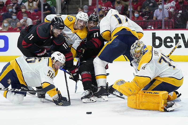 Carolina Hurricanes center Jordan Staal (11) and right wing Jesper Fast (71) struggle for the puck against Nashville Predators goaltender Juuse Saros (74) while Predators left wing Erik Haula (56), left wing Tanner Jeannot and defenseman Ben Harpur (17) defend during the second period in Game 5 of an NHL hockey Stanley Cup first-round playoff series in Raleigh, N.C., Tuesday, May 25, 2021. (AP Photo/Gerry Broome)