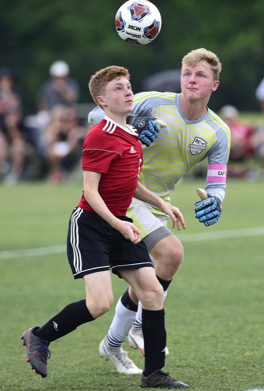 Staff Photo by Robin Rudd / Signal Mountain's Milo Newton (6) and Madison Magnet goalkeeper Jed McWherter (25) fight for control of the ballin TSSAA Spring Fling action in Murfreesboro on May 25, 2021.