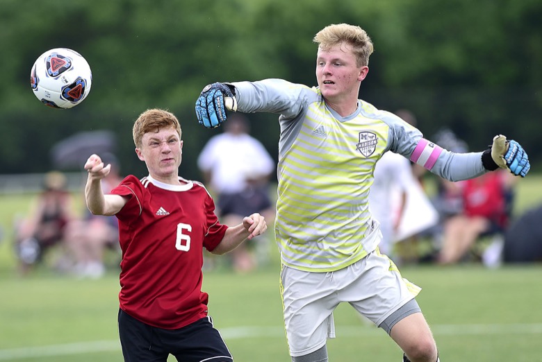 Staff Photo by Robin Rudd / Signal Mountain's Milo Newton (6) and Madison Magnet goalkeeper Jed McWherter (25) fight for control of the ballin TSSAA Spring Fling action in Murfreesboro on May 25, 2021.