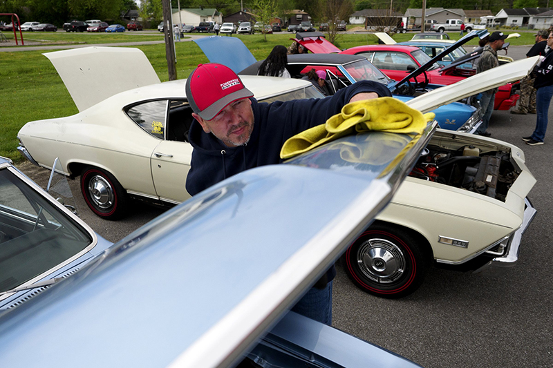 Staff photo by C.B. Schmelter / Scott White cleans the hood of his 1967 Chevelle SS.