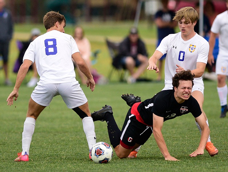 Staff photo by Robin Rudd /  A Franklin Grace player goes down between Boyd-Buchanan's Cam Park (8) and Jake Logan during a TSSAA Division II-A soccer state semifinal at the Spring Fling on Wednesday in Murfreesboro, Tenn.