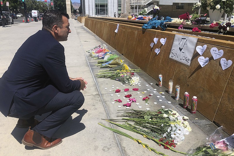 San Jose Mayor Sam Liccardo stops to view a makeshift memorial for the rail yard shooting victims in front of City Hall in San Jose, Calif., on Thursday, May 27, 2021. An employee opened fire Wednesday at a California rail yard, killing eight people before taking his own life as law enforcement rushed in, authorities said, marking the latest attack in a year that has seen a sharp increase in mass killings as the nation emerges from coronavirus restrictions. (AP Photo/Haven Daley)