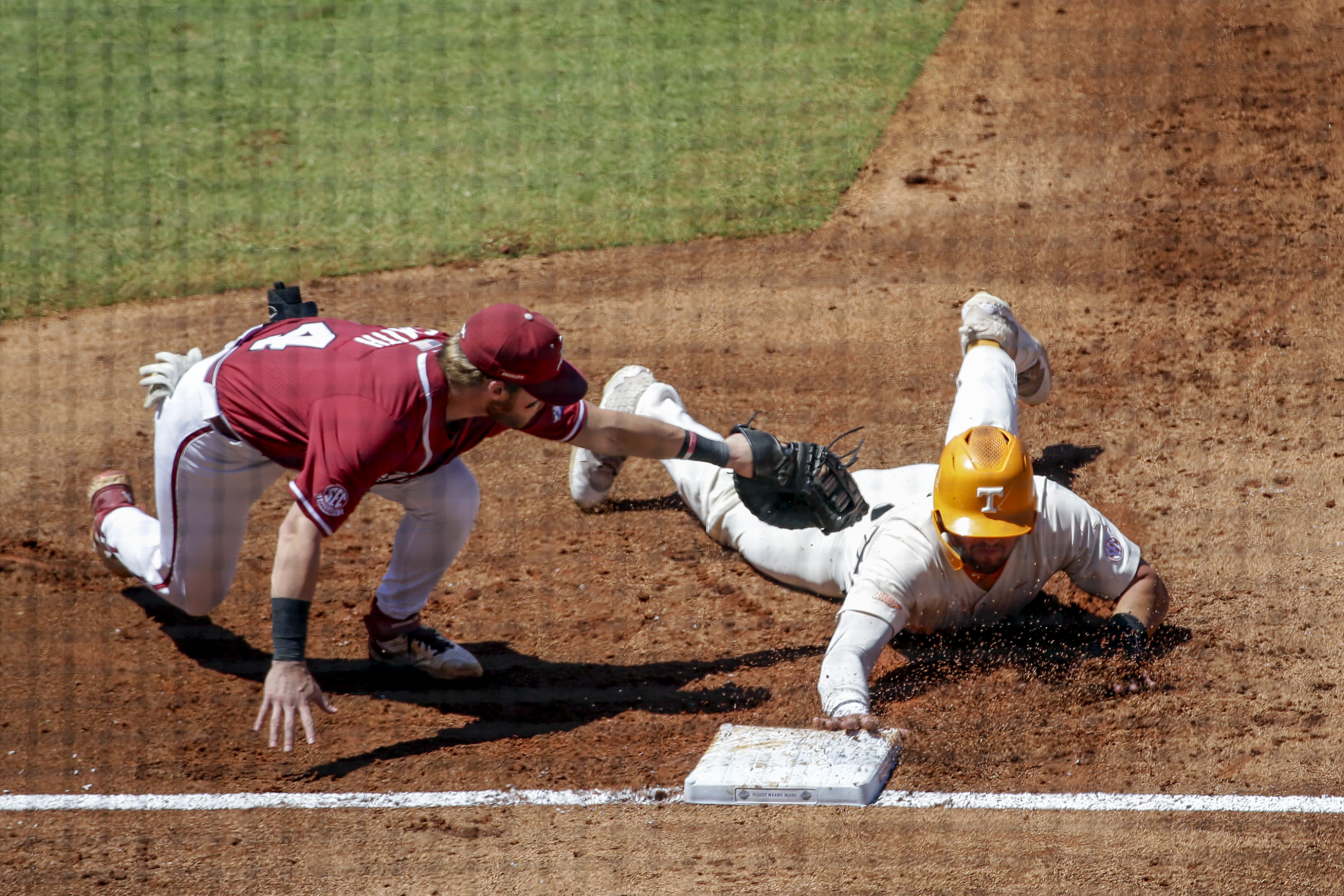 Tennessee's Pete Derkay (10) beats the tag from Arkansas first baseman Cullen Smith (14) as he dives back to first base in the second inning of an NCAA college baseball championship game during the Southeastern Conference tournament Sunday, May 30, 2021, in Hoover, Ala. (AP Photo/Butch Dill)