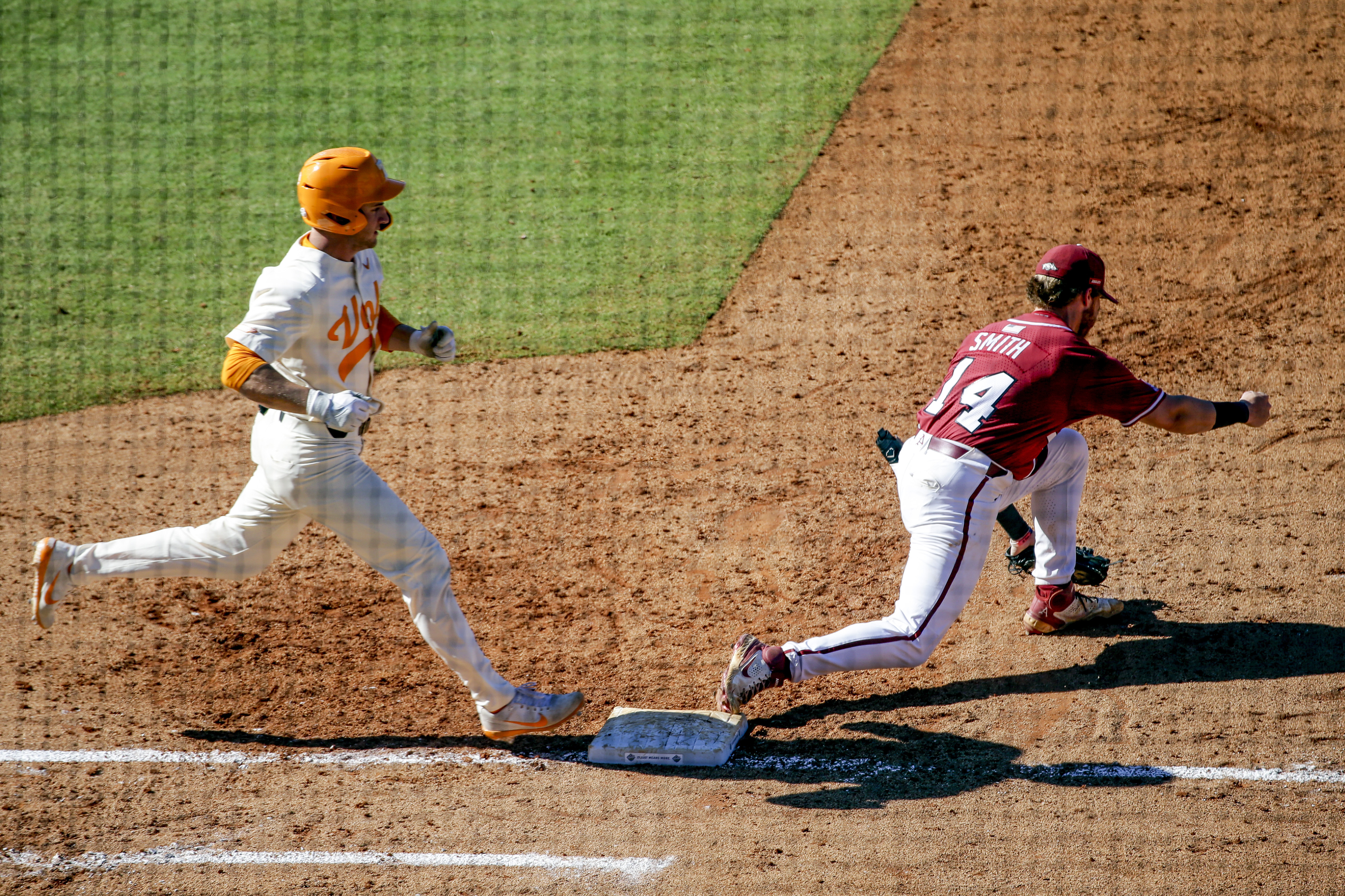 Arkansas first baseman Cullen Smith (14) gets the out on Tennessee's Evan Russell (6) in the ninth inning of an NCAA college baseball championship game during the Southeastern Conference tournament Sunday, May 30, 2021, in Hoover, Ala. (AP Photo/Butch Dill)