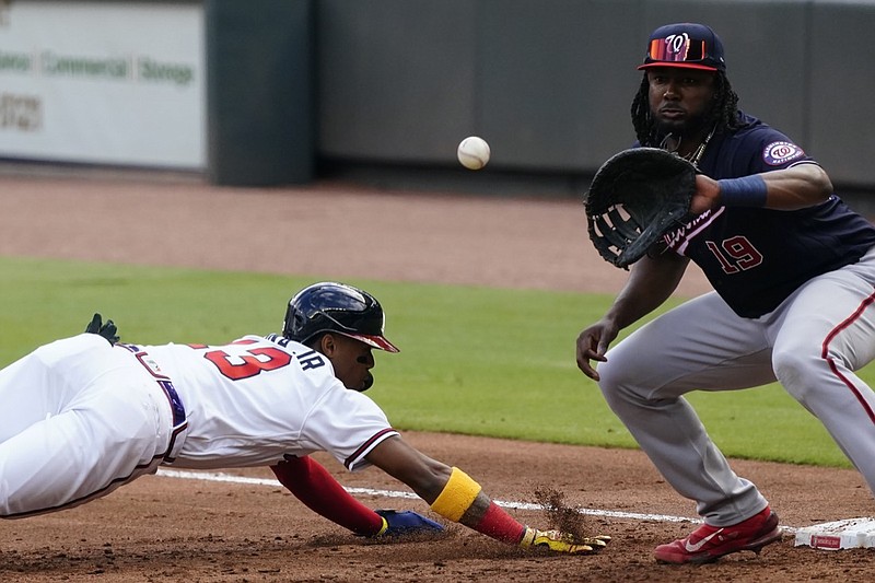 Atlanta Braves' Ronald Acuna Jr. (13) dives back to first base ahead of a throw to Washington Nationals first baseman Josh Bell (19) in the first inning of a baseball game Monday, May 31, 2021, in Atlanta. (AP Photo/John Bazemore)