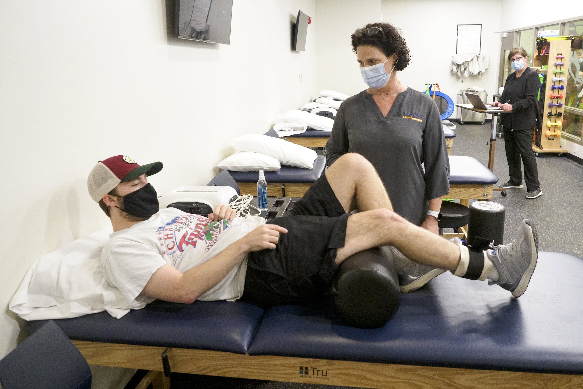 Staff photo by C.B. Schmelter / Physical Therapist Shawn Craig, center, works with patient Walker Frederick at One to One Health on Thursday, May 27, 2021 in Chattanooga, Tenn.