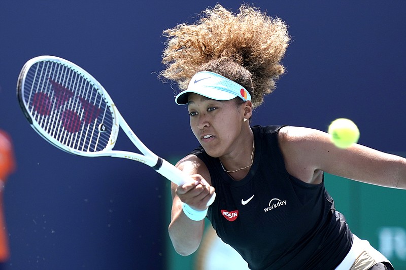 FILE - In this March 31, 2021 file photo, Naomi Osaka, of Japan, returns to Maria Sakkari, of Greece, during the quarterfinals of the Miami Open tennis tournament in Miami Gardens, Fla. Sponsors of Osaka are sticking by the her after she withdrew from the French Open citing mental health issues relating to the press conferences required for players. Osaka, a four-time Grand Slam champion, said Monday, May 31, she was withdrawing from the French Open for mental health issues. (AP Photo/Lynne Sladky, File)