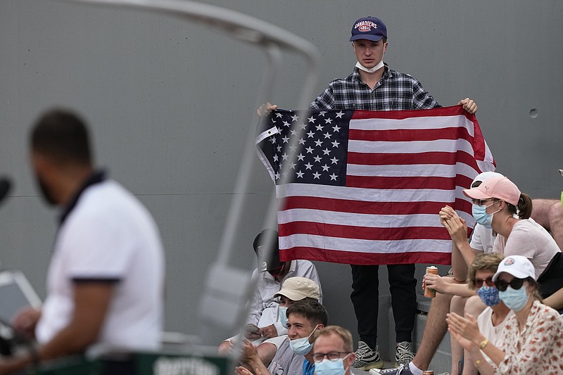 AP photo by Michel Euler / A spectator holds up an American flag as he watches John Isner play Filip Krajinovic on Wednesday at the French Open. Isner, who won 7-6 (8), 6-1, 7-6 (7), is one of four U.S. men still in the singles bracket for the third round of the clay court major. Eight American women remain in Paris.