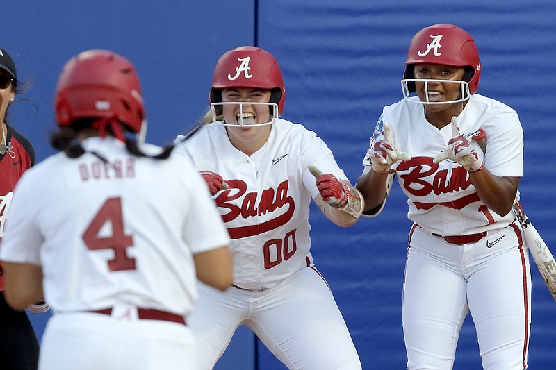 The Oklahoman photo by Bryan Terry via AP / Alabama's Maddie Morgan (00) and Eliisa Brown (1) greet Abby Doerr at the plate after she hit a home run in the sixth inning against Arizona in the opening round of the Women's College World Series on Thursday night in Oklahoma City.