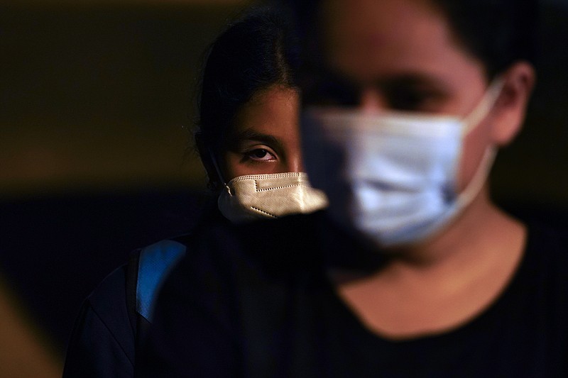 AP file photo by Gregory Bull / Marely, 12, of El Salvador, center, waits to be processed by authorities after turning herself in upon crossing the U.S. - Mexico border on May 11 in La Joya, Texas.