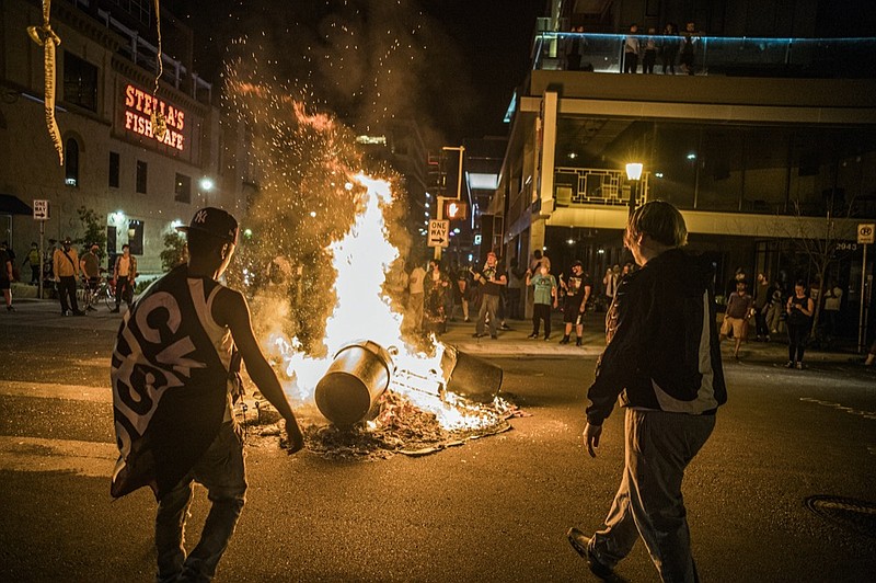 Protesters set a dumpster on fire after a shooting on Thursday, June 3, 2021 in Minneapolis. Crowds vandalized buildings and stole from businesses in Minneapolis' Uptown neighborhood after officials said a man wanted for illegally possessing a gun was fatally shot by authorities. (Richard.Tsong-Taatari/Star Tribune via AP)


