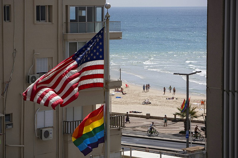 FILE - In this Thursday, June 12, 2014 file photo, a U.S. flag is raised alongside a pride flag on the U.S. Embassy a day before the Gay Pride Parade in Tel Aviv, Israel. (AP Photo/Oded Balilty, File)