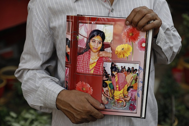 Radha Gobindo Pramanik holds photographs of his daughter who died of COVID-19 in Lucknow, India, Thursday, June 3, 2021. Two months ago Pramanik and his wife threw a party to celebrate their daughter's pregnancy and the upcoming birth of their long-awaited grandchild. Within days, his wife, his daughter and his unborn grandchild were all dead, among the tens of thousands killed as the coronavirus ravaged India in April and May. (AP Photo/Rajesh Kumar Singh)