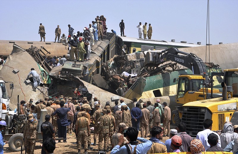 Soldiers and volunteers work at the site of a train collision in the Ghotki district in southern Pakistan, Monday, June 7, 2021. Two express trains collided in southern Pakistan early Monday, killing dozens of passengers, authorities said, as rescuers and villagers worked to pull injured people and more bodies from the wreckage. (AP Photo/Waleed Saddique)