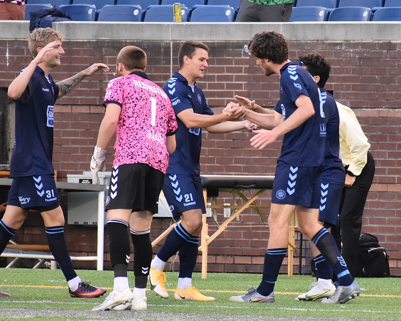 Staff photo by Patrick MacCoon / Chattanooga FC's James Kasak, middle, celebrates with Ian McGrath, right, after Kasak assisted McGrath's goal in Saturday's 2-0 victory over New Amsterdam FC at Finley Stadium.