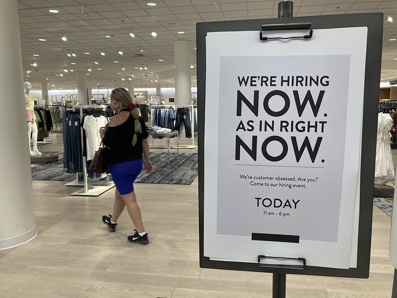 A customer walks behind a sign at a Nordstrom store seeking employees, Friday, May 21, 2021, in Coral Gables, Fla. (AP Photo/Marta Lavandier)



