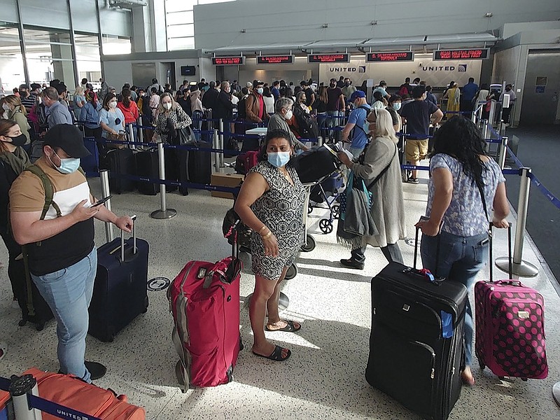 FILE - In this Sunday, May 16, 2021, file photo, airline passengers wait to check-in at George Bush Intercontinental Airport in Houston. (AP Photo/David J. Phillip, File)


