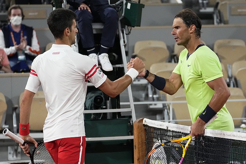 AP photo by Michel Euler /Novak Djokovic, left, shakes hands with Rafael Nadal after their French Open semifinal Friday night in Paris. Djokovic won 3-6, 6-3, 7-6 (4), 6-2 to reach Sunday's final, where he'll face Stefanos Tsitsipas.