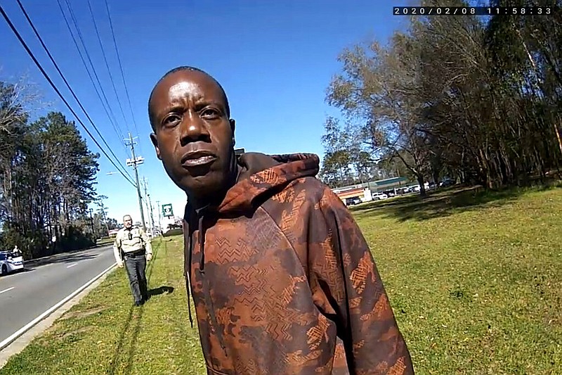 In this still image from a body camera video released by the Valdosta police, Antonio Arnelo Smith speaks to an officer as Sgt. Billy Wheeler approaches him from behind in Valdosta, Ga., on Feb. 8, 2020. The video shows Smith handing his driver's license to a police officer and answering questions cooperatively before Wheeler wraps him in a bear hug and slams him face-first to the ground. Smith is crying in pain when he's told there's a warrant for his arrest. Officers are then told the warrant was for someone else. Valdosta's City Council on Thursday, June 11, 2021, approved an offer of $350,000, to settle an excessive force lawsuit Smith filed last year against Valdosta police and other city officials. (Valdosta Police via AP, File)