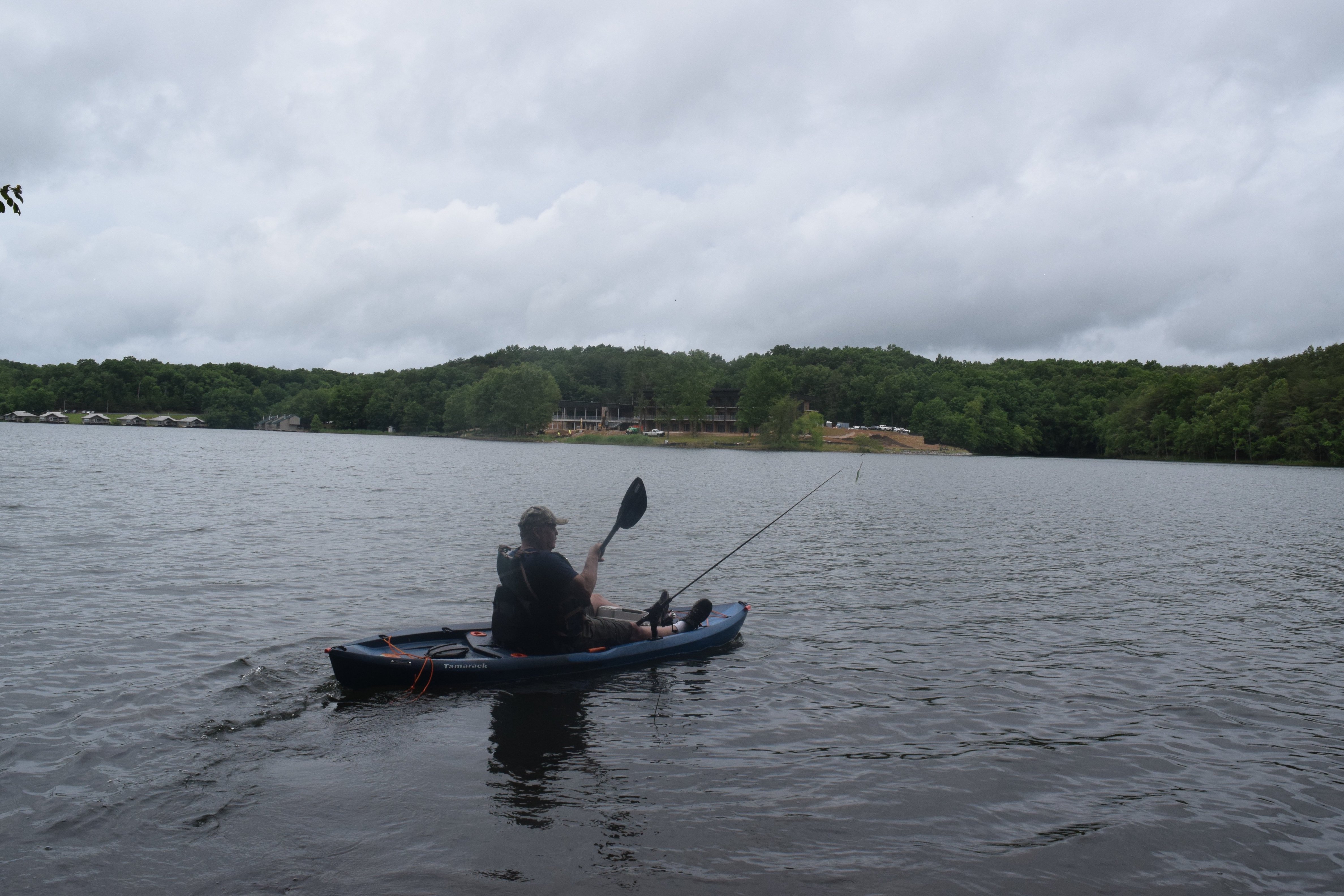 Staff photo by Ben Benton / Crossville, Tenn., resident Richard Walker paddles his fishing kayak on Fall Creek Falls Lake Wednesday, June 9, 2021, where the new $40.4 million Fall Creek Falls Lodge, shown in the background, is taking shape at Fall Creek Falls State Park. State officials say the lodge will be completed by the end of the year.
