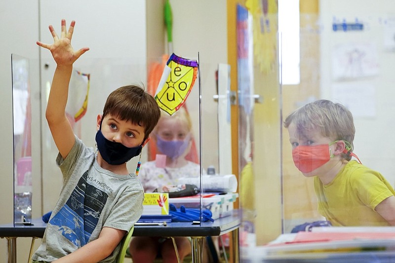 FILE - In this May 18, 2021, file photo, kindergarten students wear masks and are separated by plexiglass during a math lesson at the Milton Elementary School, in Rye, N.Y. School districts across the United States are hiring additional teachers in anticipation of what will be one of the largest kindergarten classes ever as enrollment rebounds following the pandemic. (AP Photo/Mary Altaffer, File)

