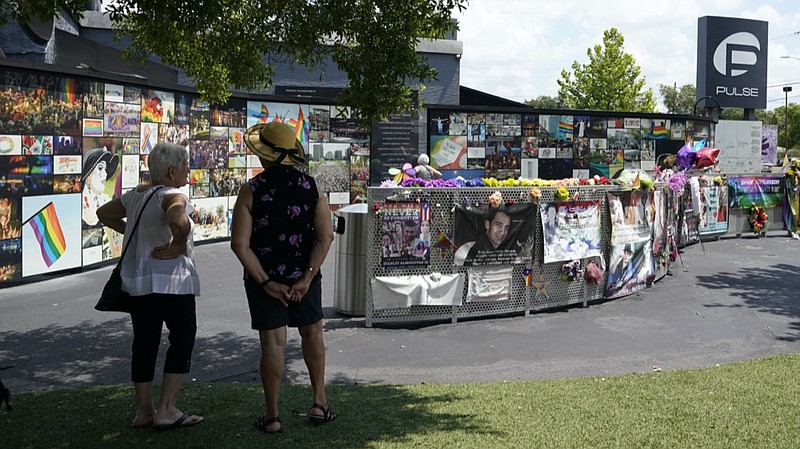 Visitors pay tribute to the display outside the Pulse nightclub memorial Friday, June 11, 2021, in Orlando, Fla. Saturday will mark the fifth anniversary of the mass shooting at the site. (AP Photo/John Raoux)