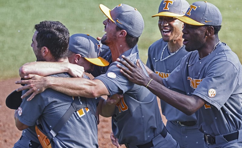 Tennessee pitcher Redmond Walsh, second from left,is mobbed by teammates after an NCAA college baseball super regional game against LSU, Sunday, June 13, 2021, in Knoxville, Tenn. (AP Photo/Wade Payne)