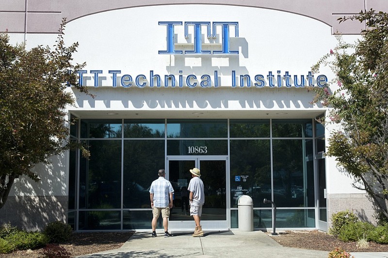 FILE - Students find the doors locked to the ITT Technical Institute campus in Rancho Cordova, Calif. The U.S. Education Department says it's erasing student debt for thousands of borrowers who attended a for-profit college chain that made exaggerated claims about its graduates' success in finding jobs. The Biden administration is approving 18,000 loan forgiveness claims from former students of ITT Technical Institute, a chain that closed in 2016. (AP Photo/Rich Pedroncelli, File)