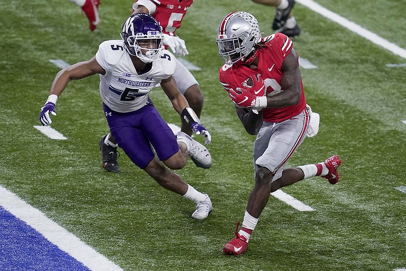 AP photo by Darron Cummings / Ohio State running back Trey Sermon, right, scores past Northwestern defensive back JR Pace during the Big Ten championship game in December 2020 in Indianapolis.