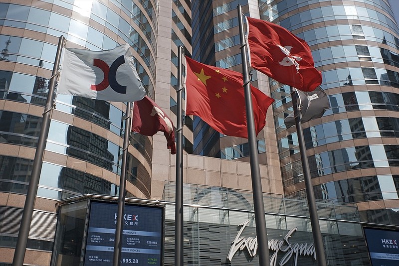 FILE - In this Oct. 9, 2019, file photo, flags are raised outside the Hong Kong Exchange Square building in Central of Hong Kong. (AP Photo/Kin Cheung, File)


