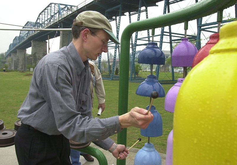 Staff File Photo / Local composer Jonathan B. McNair plays on an interactive sound sculpture that he created called Heavy Metal at Coolidge Park. For International Make Music Day, McNair will show participants how to make music using flower pots.
