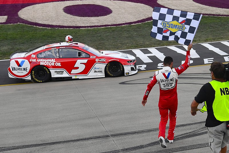 AP photo by John Amis / Kyle Larson walks back to his car with the checkered flag after winning Sunday's NASCAR Cup Series race at Nashville Superspeedway in Lebanon, Tenn.