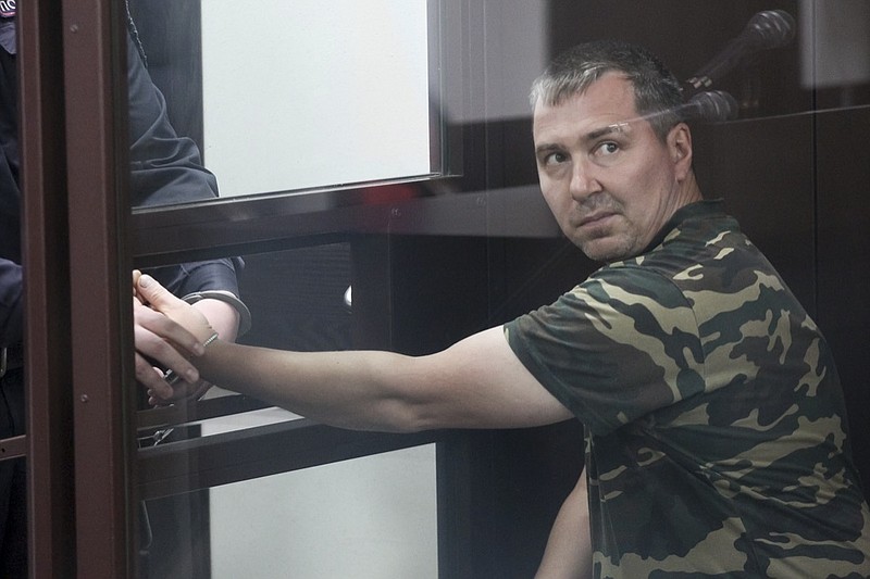 Alexander Popov, a man who was arrested on suspicion of murder sits behind the glass in a courtroom in the city of Gorodets, 60 km. (36 miles) north-west of Nizhny Novgorod, Russia, Sunday, June 20, 2021. A court in central Russia has arraigned the suspect on murder charges in the death of an American woman studying at a local university. The body of 34-year-old Catherine Serou was found Saturday in the woods area near the city of Nizhny Novgorod, 400 kilometers (250 miles) east of Moscow. (AP Photo/Roman Yarovitsyn)